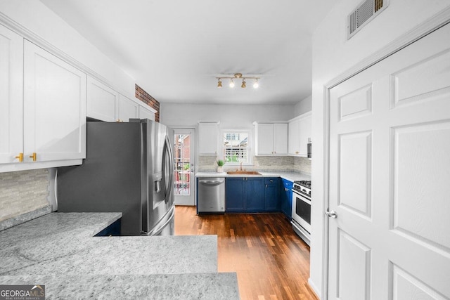 kitchen with white cabinets, stainless steel appliances, dark wood-type flooring, sink, and blue cabinets