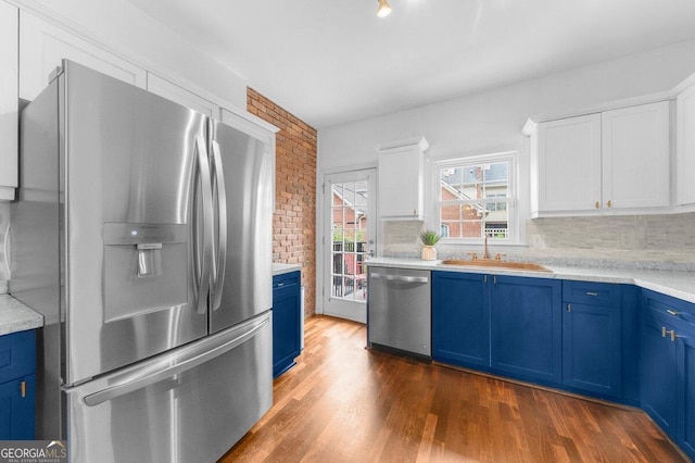 kitchen with backsplash, white cabinetry, blue cabinets, appliances with stainless steel finishes, and dark hardwood / wood-style flooring