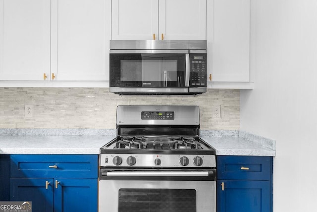 kitchen featuring blue cabinets, appliances with stainless steel finishes, white cabinetry, and tasteful backsplash