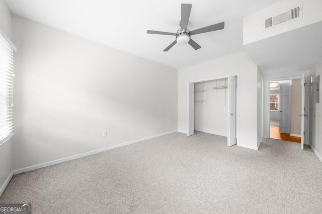 unfurnished bedroom with light carpet, a closet, and ceiling fan