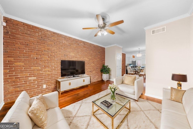 living room featuring ornamental molding, light hardwood / wood-style floors, and ceiling fan