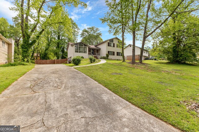 view of front of home featuring a sunroom and a front yard