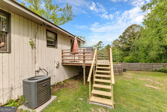 view of yard with central air condition unit and a deck