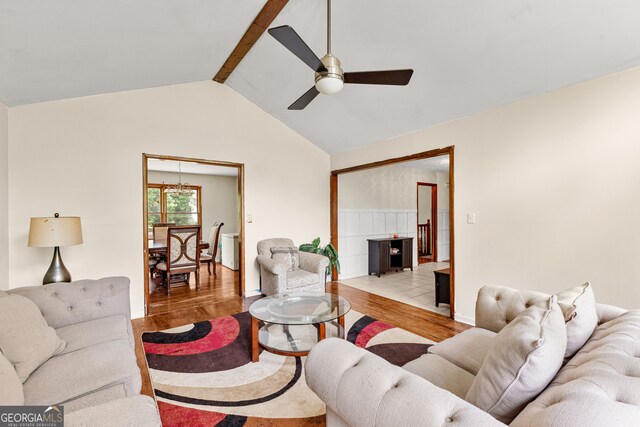 living room featuring lofted ceiling with beams, light wood-type flooring, and ceiling fan