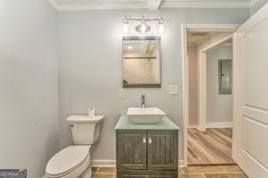 bathroom with ornamental molding, hardwood / wood-style floors, vanity, and toilet