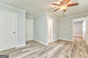 spare room with crown molding and light hardwood / wood-style floors