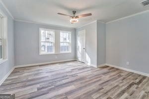 empty room featuring light hardwood / wood-style flooring, ornamental molding, and ceiling fan