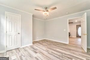 unfurnished room with ornamental molding, light hardwood / wood-style floors, and ceiling fan