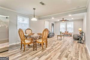 dining area with ornamental molding and hardwood / wood-style floors