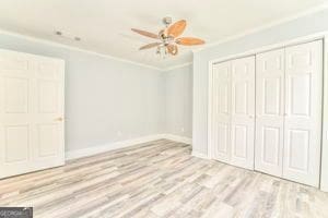 unfurnished bedroom featuring a closet, ornamental molding, light hardwood / wood-style floors, and ceiling fan