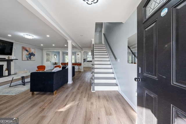 entryway with a healthy amount of sunlight, ornamental molding, and light wood-type flooring