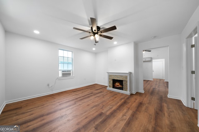 unfurnished living room with dark hardwood / wood-style flooring, a stone fireplace, ceiling fan, and cooling unit