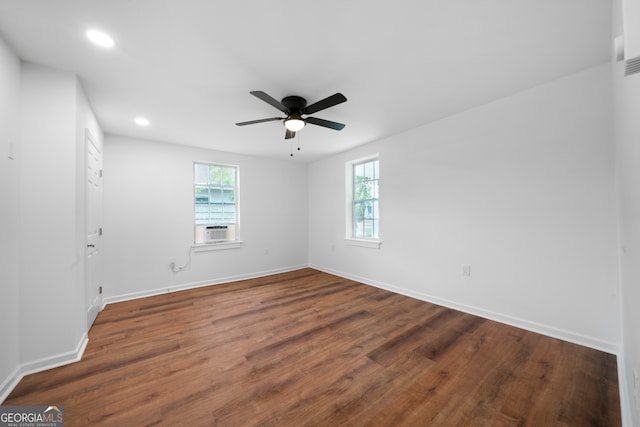 spare room featuring dark hardwood / wood-style flooring, cooling unit, and ceiling fan