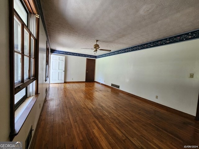 unfurnished room featuring a textured ceiling, hardwood / wood-style flooring, and ceiling fan