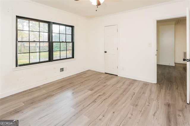 spare room featuring ornamental molding, light wood-type flooring, and ceiling fan