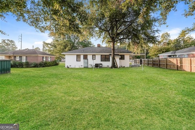 rear view of property with a yard