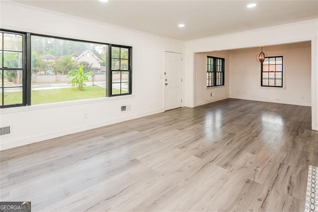 spare room with light hardwood / wood-style floors and ornamental molding