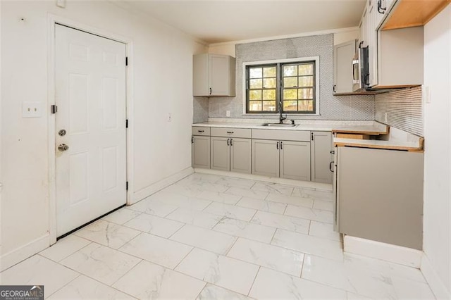 kitchen with crown molding, decorative backsplash, and sink