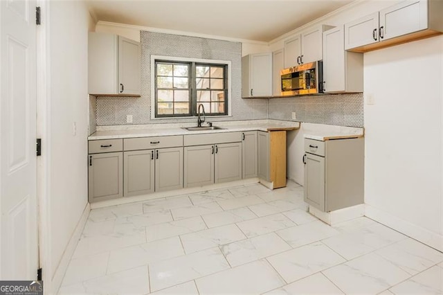 kitchen with backsplash, ornamental molding, and sink