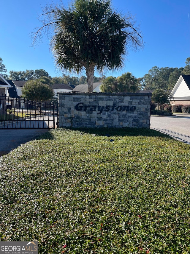 community / neighborhood sign featuring a yard