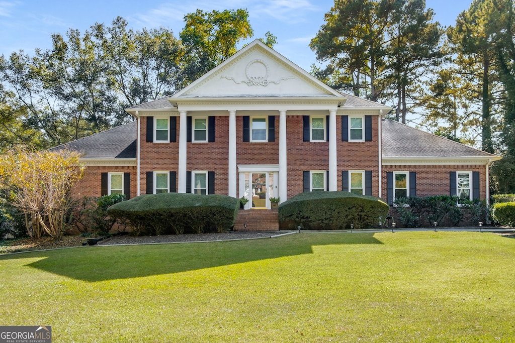 neoclassical home with a front lawn