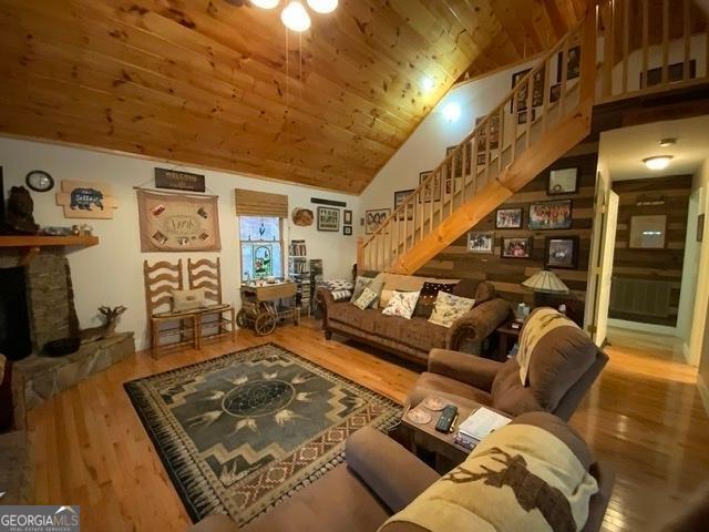 289 Cypress Cir, Ellijay, GA 30540 - living area featuring a stone fireplace, wood finished floors, wooden ceiling, high vaulted ceiling, and stairs