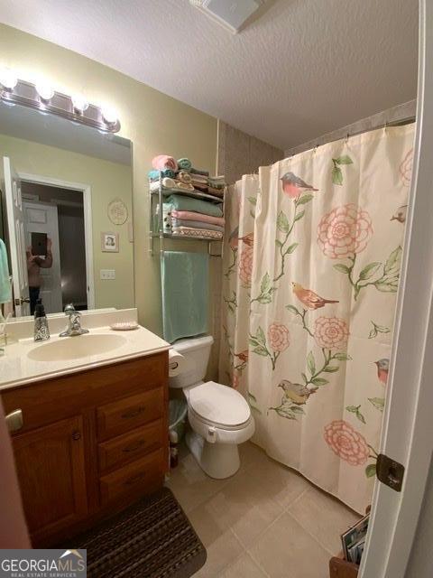 289 Cypress Cir, Ellijay, GA 30540 - bathroom with vanity, toilet, tile patterned floors, a textured ceiling, and curtained shower