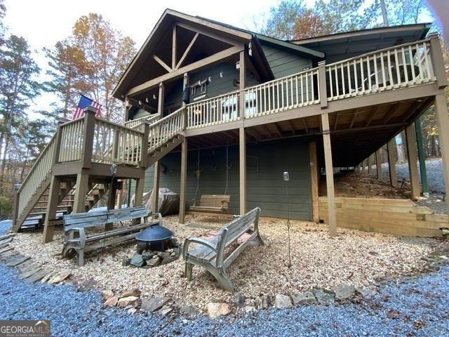 289 Cypress Cir, Ellijay, GA 30540 - back of property featuring stairway, a fire pit, and a wooden deck