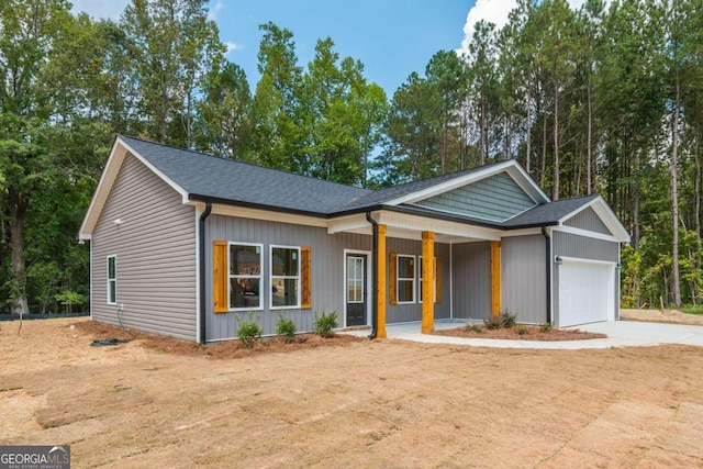 single story home featuring a porch and a garage