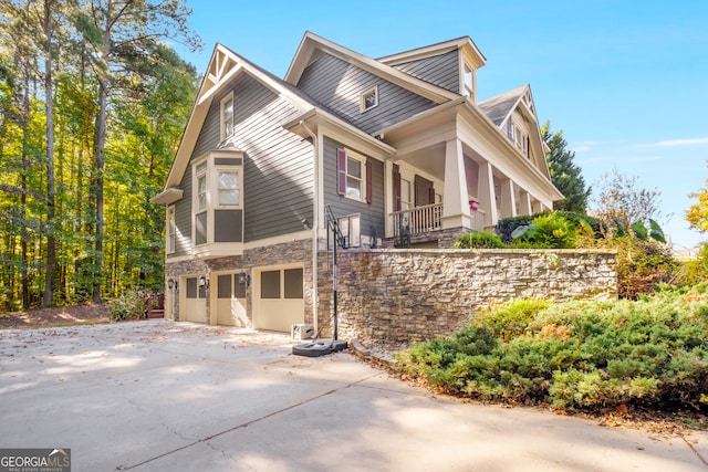 view of property exterior featuring covered porch and a garage