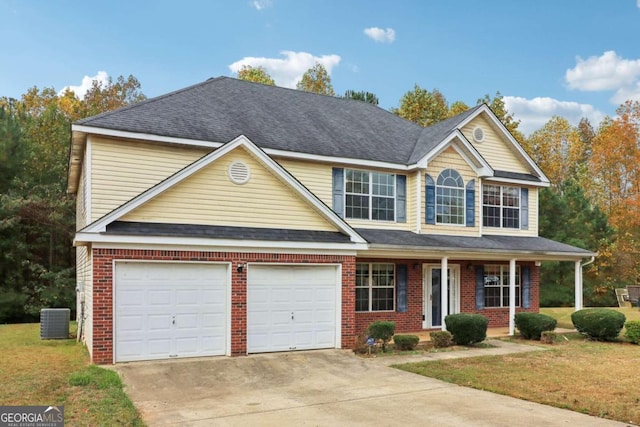 view of front of house with covered porch, central AC, a front yard, and a garage