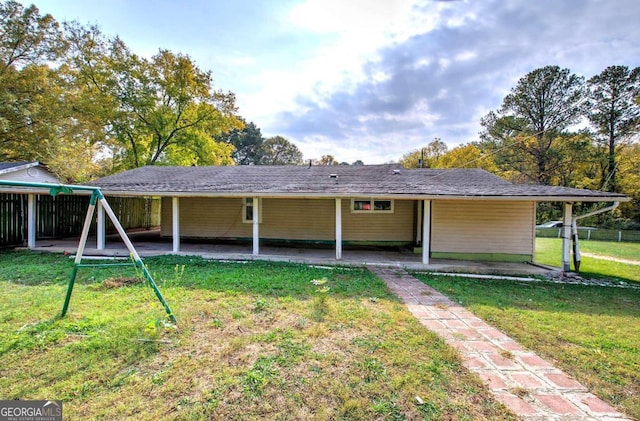 rear view of house featuring a lawn