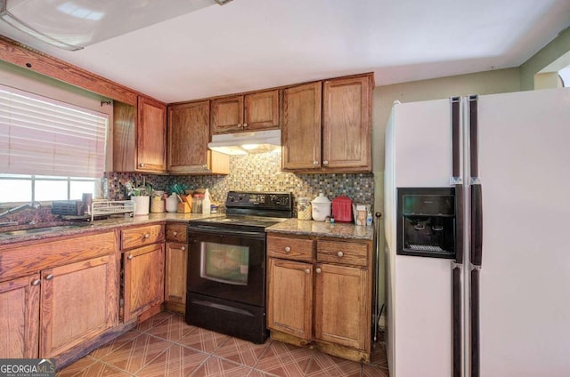 kitchen featuring white fridge with ice dispenser, tasteful backsplash, sink, stone countertops, and electric range