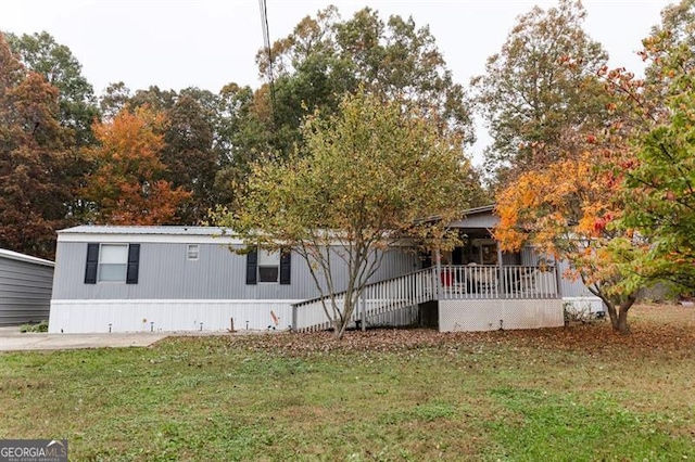 view of front of home with a wooden deck and a front lawn