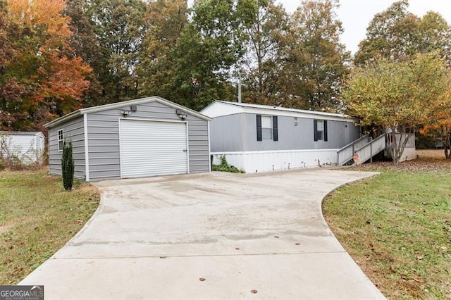 view of front of house with a front yard, an outbuilding, and a garage