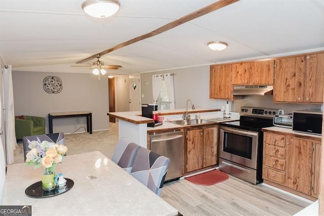 kitchen featuring lofted ceiling, stainless steel appliances, backsplash, sink, and ceiling fan