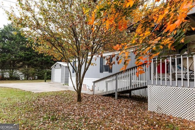 exterior space with a wooden deck, an outbuilding, and a garage