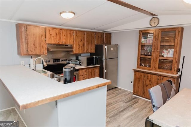 kitchen featuring light hardwood / wood-style floors, appliances with stainless steel finishes, vaulted ceiling, and kitchen peninsula