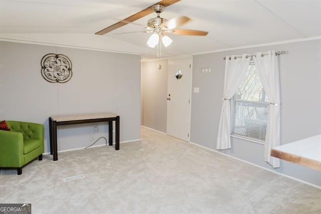 interior space featuring light carpet, ornamental molding, vaulted ceiling, and ceiling fan