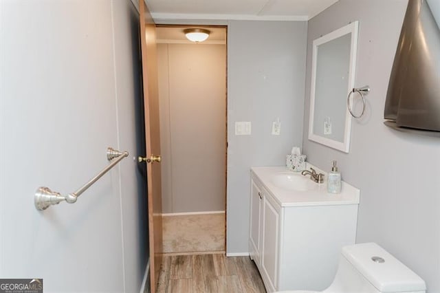 bathroom with toilet, hardwood / wood-style flooring, and vanity