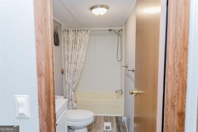 full bathroom featuring wood-type flooring, shower / tub combo, a textured ceiling, toilet, and vanity