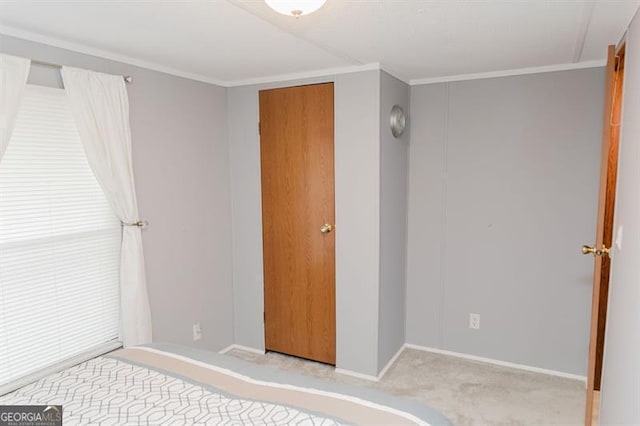 unfurnished bedroom with a closet, crown molding, and light colored carpet