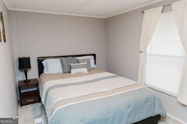 bedroom with ornamental molding and carpet flooring