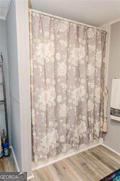 bathroom featuring hardwood / wood-style flooring and walk in shower