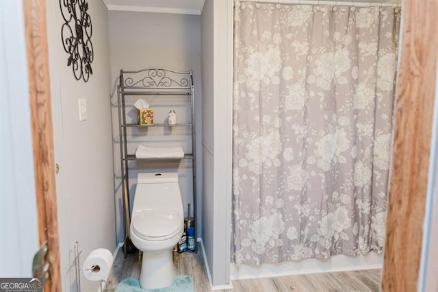 bathroom featuring toilet, hardwood / wood-style flooring, and shower / bath combo with shower curtain