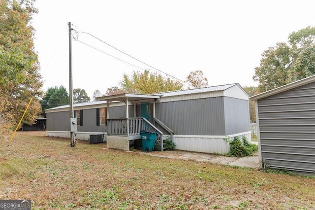 rear view of property with a lawn and central AC unit