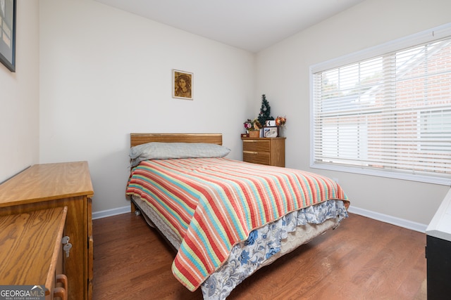 bedroom with dark hardwood / wood-style floors