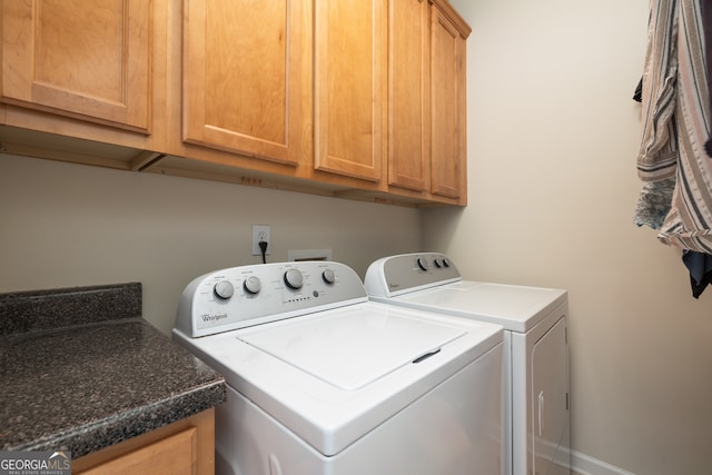 washroom with washer and clothes dryer and cabinets