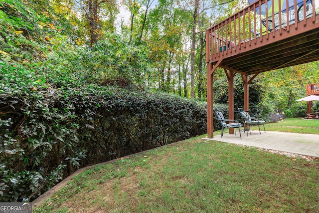 view of yard featuring a patio and a wooden deck