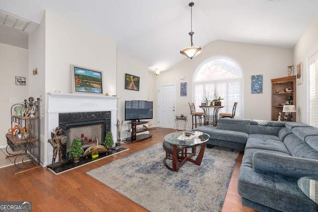 living room featuring hardwood / wood-style flooring, a premium fireplace, and lofted ceiling